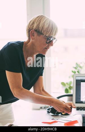 Femme travaillant à la maison en connectant un ordinateur portable Banque D'Images