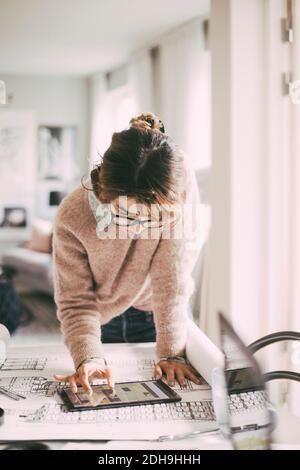 Femme architecte travaillant sur une tablette au bureau à la maison Banque D'Images