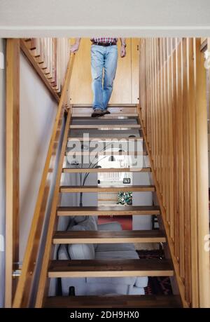 Section basse de l'homme senior marchant sur des marches en bois à accueil Banque D'Images