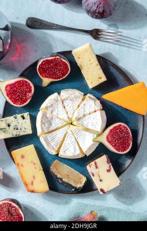 Sélection de fromages, prise verticale sur une assiette avec figues fraîches Banque D'Images