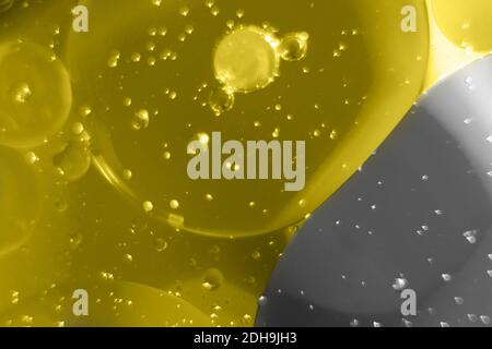 Fluide macro avec bulles, arrière-plan abstrait gris et jaune. Défoqué. Couleur 2021. Banque D'Images