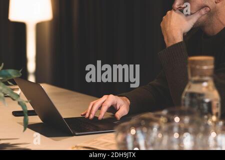 Image rognée d'un homme d'affaires attentionné utilisant un ordinateur portable au bureau bureau Banque D'Images