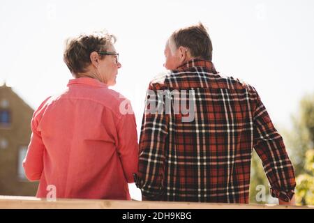 Vue arrière d'un couple senior regardant l'un l'autre pendant debout contre le ciel dégagé Banque D'Images