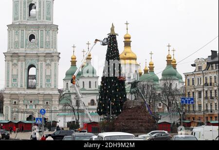 Des ouvriers municipaux ont installé et décorent le principal arbre de Noël de l'Ukraine devant la cathédrale Sainte-Sophie à Kiev en préparation des fêtes de Noël et du nouvel an. Banque D'Images