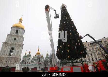 Des ouvriers municipaux ont installé et décorent le principal arbre de Noël de l'Ukraine devant la cathédrale Sainte-Sophie à Kiev en préparation des fêtes de Noël et du nouvel an. Banque D'Images