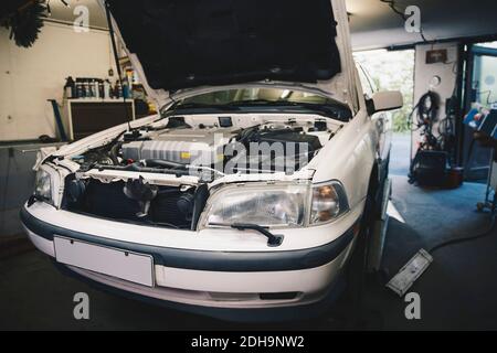 Voiture avec le capot ouvert à l'atelier de réparation automobile Banque D'Images