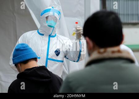 (201210) -- CHENGDU, 10 décembre 2020 (Xinhua) -- UN membre du personnel médical informe les résidents des choses à faire et à ne pas faire pour les tests COVID-19 à l'hôpital de médecine traditionnelle chinoise du district de Pidu à Chengdu, capitale de la province du Sichuan, dans le sud-ouest de la Chine, le 10 décembre 2020. Chengdu a signalé une augmentation nulle des nouveaux cas de COVID-19 transmis au pays et des cas asymptomatiques entre 9 h mardi et 6 h mercredi, tandis que les tests d'acide nucléique à l'échelle de la ville se poursuivent, ont déclaré les autorités locales. Au Pidu District Hospital of Traditional Chinese Medicine, des travailleurs médicaux ont travaillé 2 Banque D'Images