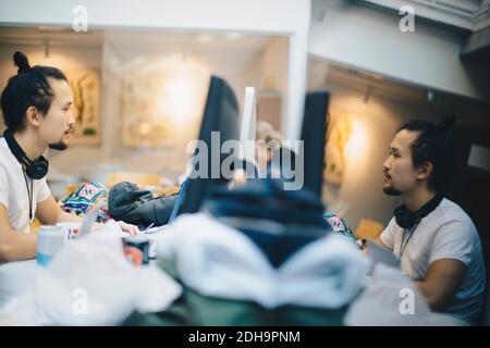 Vue latérale d'un programmeur travaillant sur un ordinateur au bureau Banque D'Images