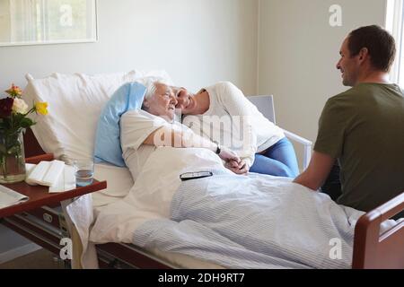 Couple rendant visite à un homme âgé à l'hôpital Banque D'Images