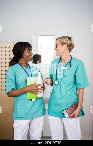 Souriant, les femmes qui travaillent dans le secteur de la santé parlent en se tenant à la clinique Banque D'Images