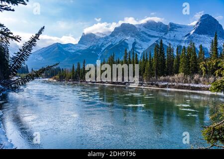 Paysage naturel en début de saison d'hiver ensoleillé jour matin. Dérive de glace flottant sur la rivière Bow. Ciel bleu clair, enneigé Mont Lawrence Grassi Banque D'Images