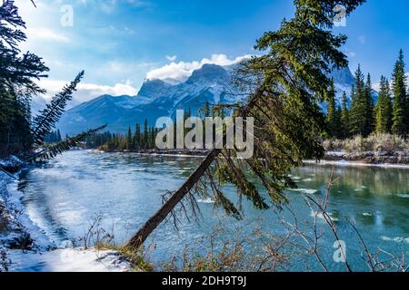 Paysage naturel en début de saison d'hiver ensoleillé jour matin. Dérive de glace flottant sur la rivière Bow. Ciel bleu clair, enneigé Mont Lawrence Grassi Banque D'Images