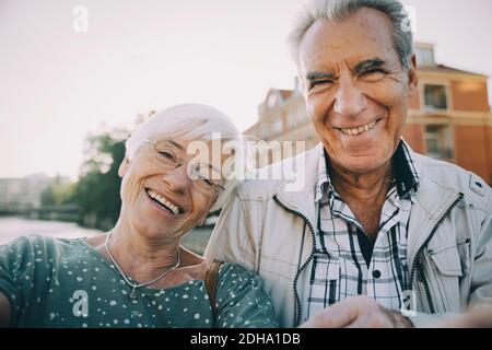 Portrait d'un homme et d'une femme de haut niveau souriant debout en ville Banque D'Images