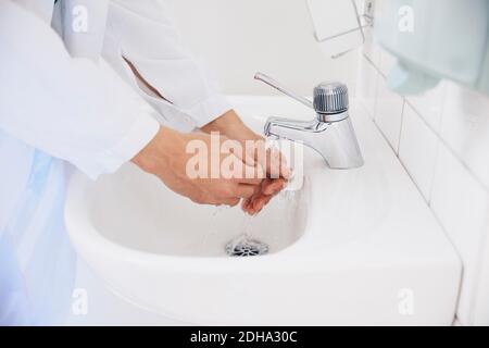 Culture d'un médecin se lavant les mains dans l'évier de l'hôpital Banque D'Images