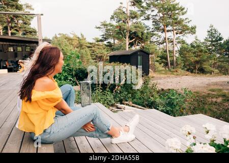 De jeunes femmes heureuses assises sur la terrasse du cottage Banque D'Images