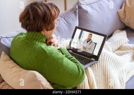 Photo d'une femme sénior malade à la maison pendant la cousultation en ligne avec un médecin. Concept de soins de santé. Banque D'Images