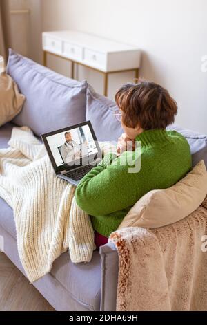 Femme sénior malade à la maison pendant la cousultation en ligne avec un médecin. Concept de soins de santé. Photo Verticacl. Banque D'Images