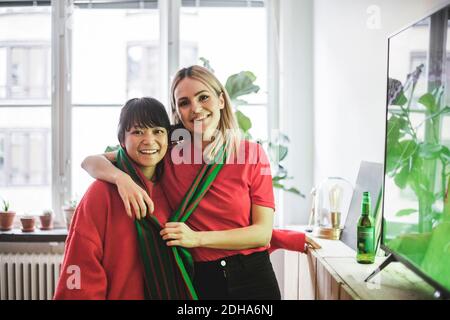 Portrait d'amis souriants debout avec le bras autour à accueil Banque D'Images