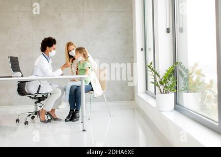 Mère avec sa petite fille à l'examen pédiatre et Avoir un test de diagnostic PCR par une femme médecin afro-américaine Banque D'Images