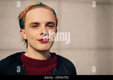 Portrait of smiling man standing against wall Banque D'Images