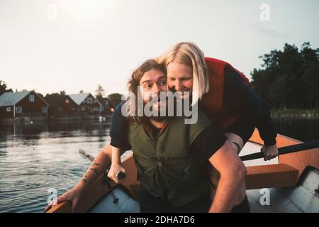 Couple heureux appréciant en bateau sur le lac contre le ciel Banque D'Images