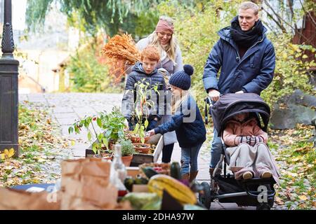 Famille arrivant à la stalle du marché Banque D'Images