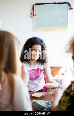 Une jeune fille enjouée avec des amis assis au restaurant table dans la chambre Banque D'Images