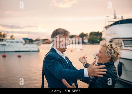 Vue latérale d'une femme âgée agitée qui embrasse l'homme au port Banque D'Images