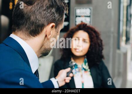 Vue arrière de l'homme d'affaires qui a interviewé une femme d'affaires en ville Banque D'Images
