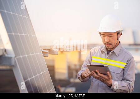 Réaliser des vérifications de la station de panneaux photovoltaïques solaires avec un ordinateur tablette. Concept de technologie de l'énergie Banque D'Images