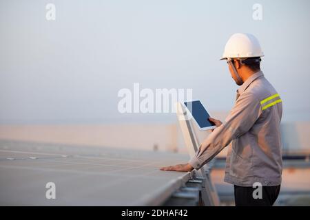 Réaliser des vérifications de la station de panneaux photovoltaïques solaires avec un ordinateur tablette. Concept de technologie de l'énergie Banque D'Images