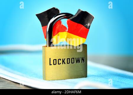FOTOMONTAGE, Geschlossenes Vorhängeschloss mit angerissener Deutschlandfahne und Aufschrift Lockdown, Spaltung der Gesellschaft durch den Lockdown Banque D'Images