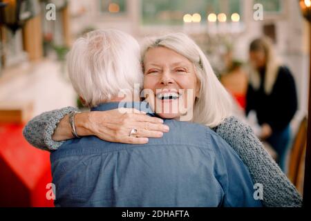 Portrait d'une femme âgée embrassant l'homme tout en étant debout à la maison Banque D'Images