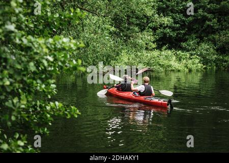 Vue arrière de l'homme et de la femme en kayak de mer pendant la formation Banque D'Images