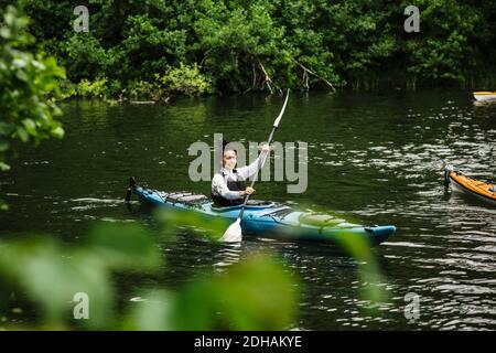 Femme âgée pagayant en kayak de mer pendant le cours de kayak Banque D'Images