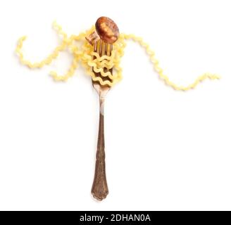 Pâtes italiennes. Une photo en hauteur d'une fourchette de style vintage avec de longs fusilli et un champignon frit sur un fond blanc Banque D'Images