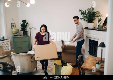 Heureux couple déballant les boîtes dans le salon à la nouvelle maison Banque D'Images