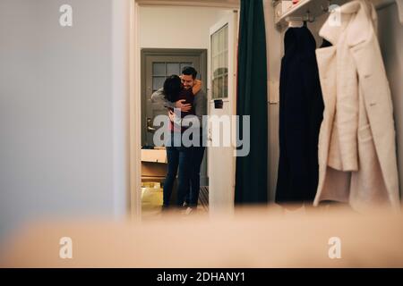 Couple embrassant vu de la porte dans le nouvel appartement Banque D'Images