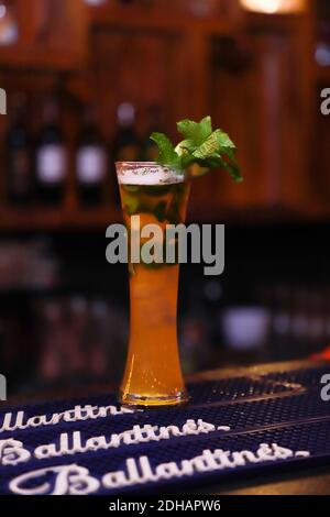 cocktail de bière dans un grand verre de martini garniture avec des feuilles de menthe Banque D'Images