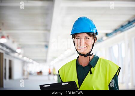 Portrait d'une femme souriante responsable de la construction en vêtements réfléchissants à site Banque D'Images