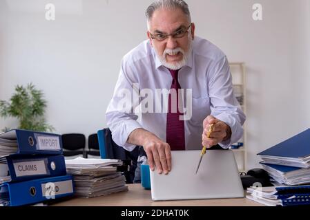 Employé de sexe masculin âgés de mécontents de l'excès de travail Banque D'Images