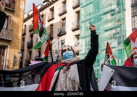 Un manifestant lève son poing dans les airs pendant la manifestation.le peuple sahraoui démontrera devant le ministère espagnol des Affaires étrangères, de l'Union européenne et de la coopération, pour exiger un accord d'autodétermination et d'indépendance du peuple sahraoui, Après la rupture récente du cessez-le-feu par le Royaume du Maroc le 13 novembre, les forces militaires marocaines ont attaqué des civils sahraouis qui manifestaient pacifiquement dans la région de Guerguerat, au sud-ouest du Sahara occidental, à la frontière de la Mauritanie. Banque D'Images