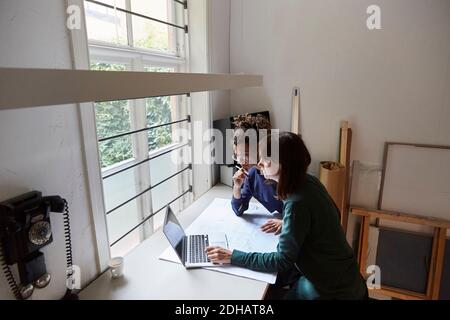 Femmes architectes planifiant sur ordinateur portable à table dans le bureau Banque D'Images