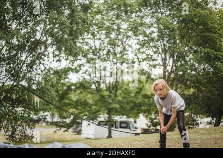 Fille préparant une tente dans la forêt au camping pendant les vacances Banque D'Images