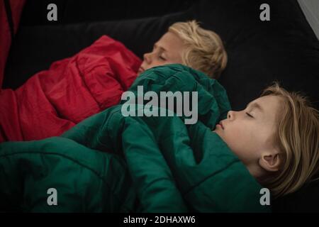 Vue en grand angle du frère et de la sœur dormant dans la tente avec les yeux fermés Banque D'Images