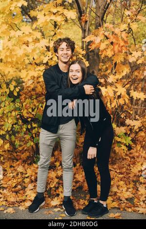 Plein de joyeux amis adolescents souriant contre les arbres à l'intérieur automne Banque D'Images