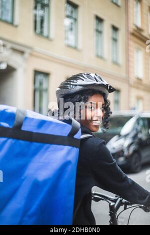 Portrait d'une femme souriante avec sac en ville Banque D'Images