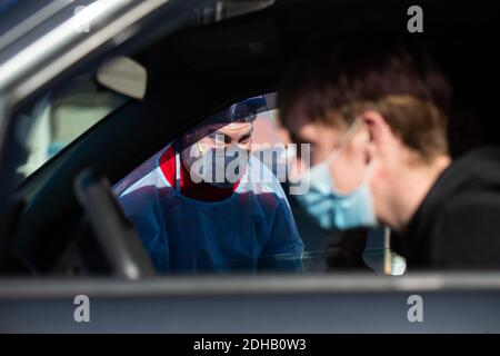 Pawtucket, États-Unis. 10 décembre 2020. Le travailleur médical Matthew Martell (L) discute avec Joseph Murphy (obscurci) et son frère Conor Murphy (R) sur un site de test COVID-19 en voiture dans le parc de stationnement du stade McCoy à Pawtucket, Rhode Island, le jeudi 10 décembre 2020. L'État a actuellement le taux de COVID-19 par habitant le plus élevé du pays. Photo par Matthew Healey/UPI crédit: UPI/Alay Live News Banque D'Images