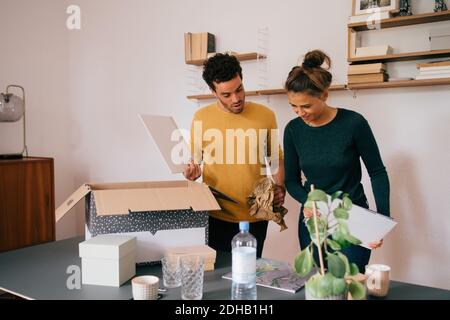 Petit ami et petite amie déballant des livres à la nouvelle maison Banque D'Images