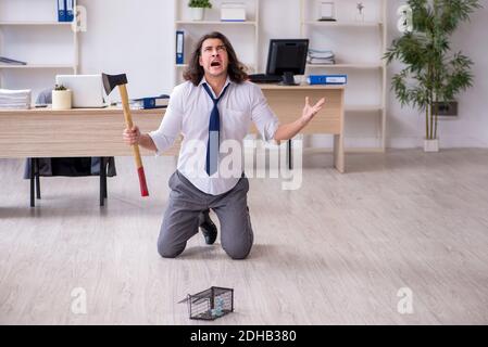 Jeune homme et mousetrap au bureau Banque D'Images